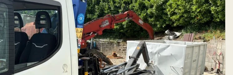 Petite benne blanche déposée par camion léger à Lyon