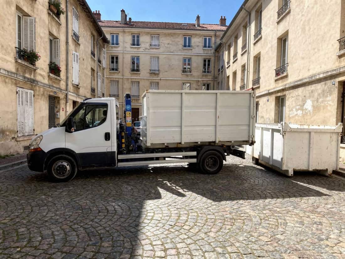 Camion-grue pour poser une benne dans une cour étroite à Villeurbanne
